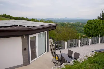 a house with a solar roof and chairs on a patio at Apartma Lara in Lesično