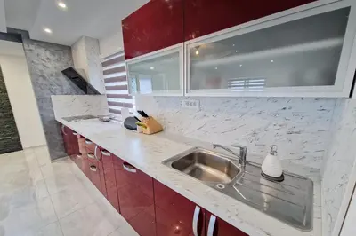 a kitchen with a sink and red cabinets at Apartma Lara in Lesično