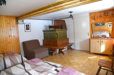 a bedroom with a bed and a chair and a piano at Pri Matičku in Bohinj