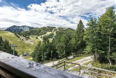 a view of a mountain with a fence and trees at Chalet Burja at Vogel mountain - cable car access or hiking - not reachable with car in Bohinj
