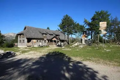 a person standing in front of a house at Chalet Burja at Vogel mountain - cable car access or hiking - not reachable with car in Bohinj