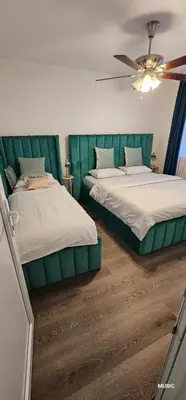 a bedroom with two beds and a ceiling fan at Apartmani MURIC Ljubljana in Ljubljana