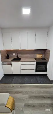 a kitchen with white cabinets and a sink at Apartmani MURIC Ljubljana in Ljubljana