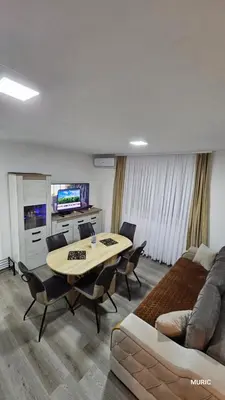 a living room with a table and a couch at Apartmani MURIC Ljubljana in Ljubljana