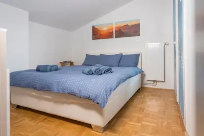 a white bedroom with a bed with blue pillows at DREAM & RELAX Apartment in Bohinj