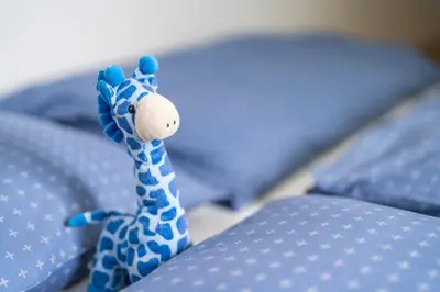 a toy giraffe sitting on top of a bed at DREAM & RELAX Apartment in Bohinj