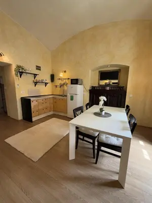 a kitchen with a white table and chairs in a room at Central Oasis-with parking in Ljubljana