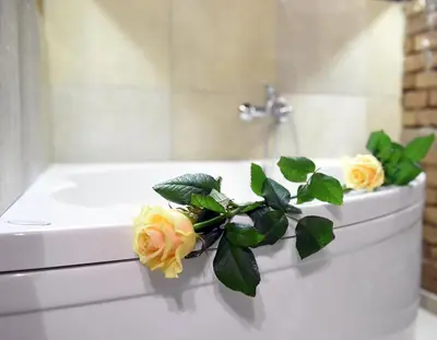a white bath tub with yellow roses on it at Central Oasis-with parking in Ljubljana