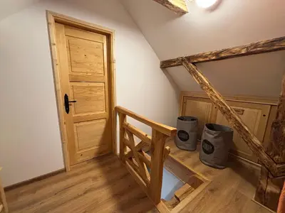 a room with a wooden staircase with two trash cans at Grunt Sonek in Mislinja
