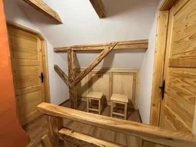 two stools in a room with wooden doors at Grunt Sonek in Mislinja