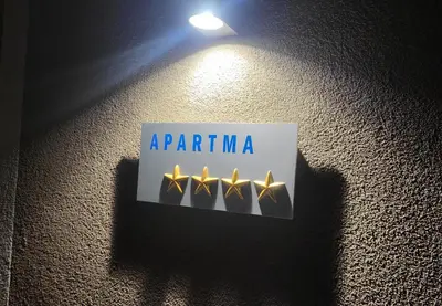 a sign on a wall with four gold lights at Landena Apartments Lendava in Lendava