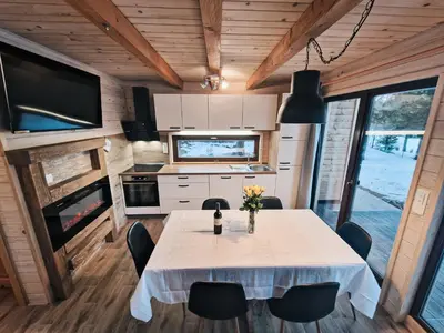 a dining room with a table in a tiny house at HIŠA ZIMAZAKON BLOKE in Nova Vas