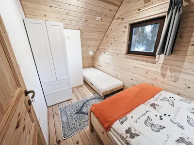 a small room with a bed and a window at HIŠA ZIMAZAKON BLOKE in Nova Vas