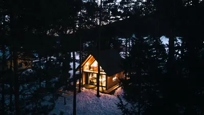 a small tree house in the woods at night at HIŠA ZIMAZAKON BLOKE in Nova Vas