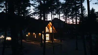 a small cabin in the woods at night at HIŠA ZIMAZAKON BLOKE in Nova Vas