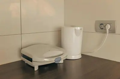 a small white appliance sitting on a wooden floor at Apartment Mountain Sunrise in Škofja Loka