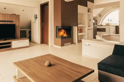 a living room with a fireplace in the middle of it at Apartment Mountain Sunrise in Škofja Loka