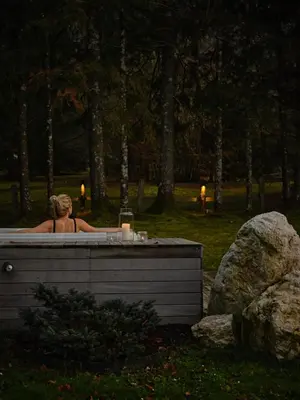 a woman sitting in a hot tub in a park at Fox on the Rocks Chalet in Bohinj