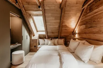 a large bed in a room with wooden walls at Fox on the Rocks Chalet in Bohinj