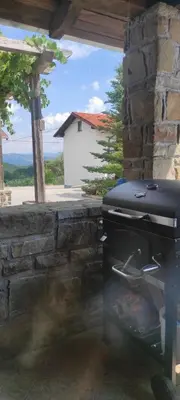 a grill sitting next to a stone wall at ADORI in Ilirska Bistrica