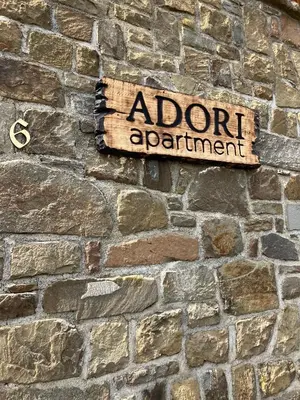 a sign on the side of a brick wall at ADORI in Ilirska Bistrica