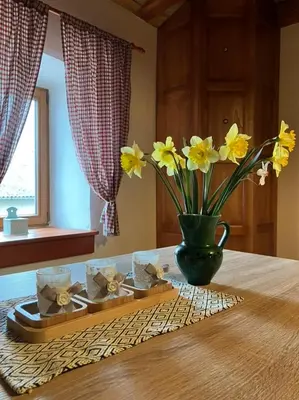 a table with a vase with yellow flowers on it at ADORI in Ilirska Bistrica