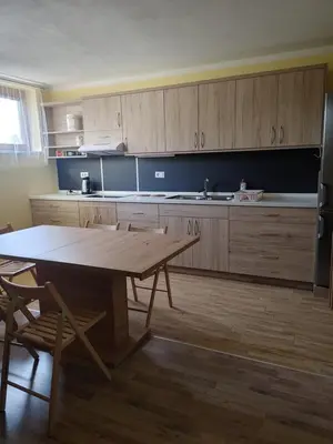 a kitchen with a wooden table and a large kitchen at Apartma svizec in Bled