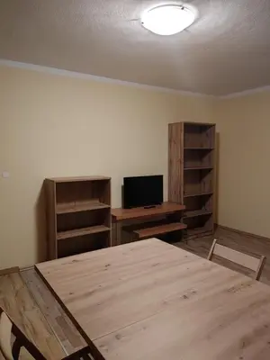 an empty room with a wooden table and a television at Apartma svizec in Bled