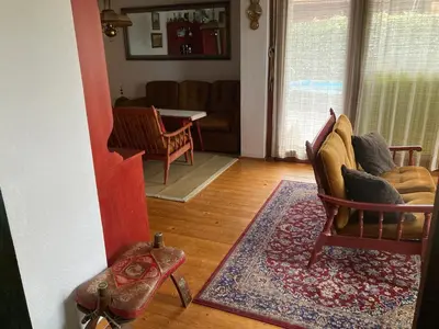 a living room with two chairs and a couch at Family lake house Zbilje in Ljubljana