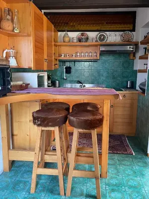 a kitchen with wooden stools at a kitchen counter at Family lake house Zbilje in Ljubljana