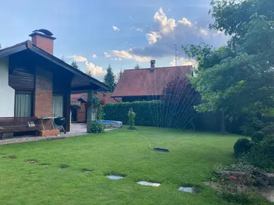 a yard with a fence next to a house at Family lake house Zbilje in Ljubljana