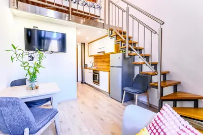 a living room with a staircase and a table and chairs at The Modern Loft in Ljubljana