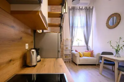 a kitchen with a living room with a couch and a table at The Modern Loft in Ljubljana