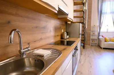 a kitchen with a stainless steel sink and wooden counters at The Modern Loft in Ljubljana