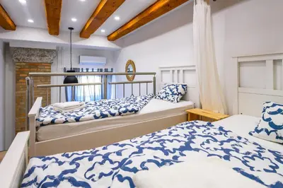 two beds in a bedroom with blue and white at The Modern Loft in Ljubljana