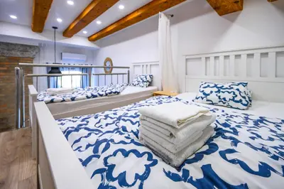 a bedroom with two beds with blue and white sheets at The Modern Loft in Ljubljana