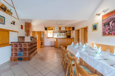 a dining room with a long table with white table cloth at Apartments PIT Zdole in Kozje