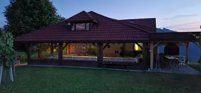a house with a pavilion with tables and chairs at Apartments PIT Zdole in Kozje