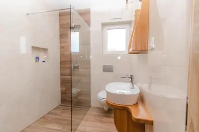 a bathroom with a sink and a glass shower at Apartments PIT Zdole in Kozje