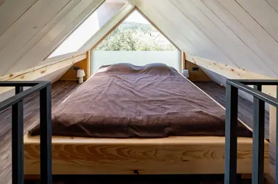 a bed in a tent with a window at Hiša Zdravega Oddiha in Begunje pri Cerknici