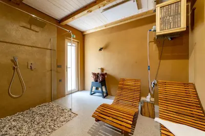 two wooden chairs in a room with a shower at Hiša Zdravega Oddiha in Begunje pri Cerknici