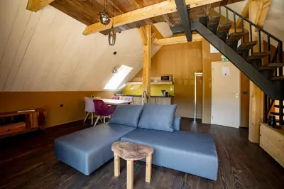 a living room with a blue couch and a table at Hiša Zdravega Oddiha in Begunje pri Cerknici