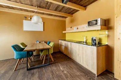 a kitchen and dining room with a table and chairs at Hiša Zdravega Oddiha in Begunje pri Cerknici