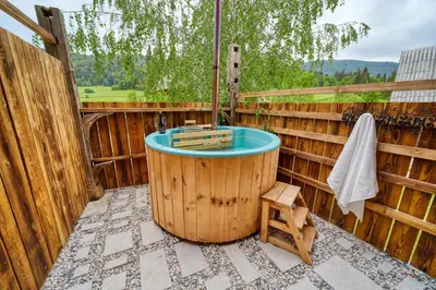 a hot tub on a patio with a wooden fence at Hiša Zdravega Oddiha in Begunje pri Cerknici