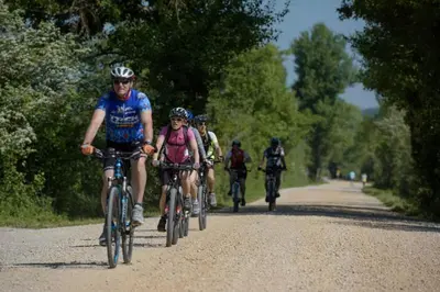 a group of people riding bikes down a road at Hiša Zdravega Oddiha in Begunje pri Cerknici