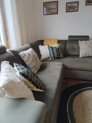 a couch with pillows on it in a living room at Luxury Wide View Apartment Pohorje Bellevue in Pohorje