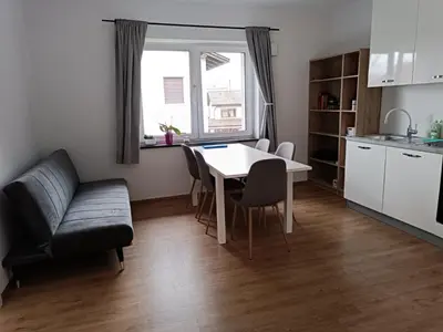 a living room with a table and a kitchen at VILA ADA - 4 Cosy Apartments in Ljubljana