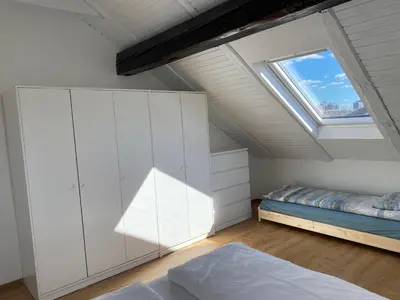 a attic bedroom with a bed and a window at VILA ADA - 4 Cosy Apartments in Ljubljana