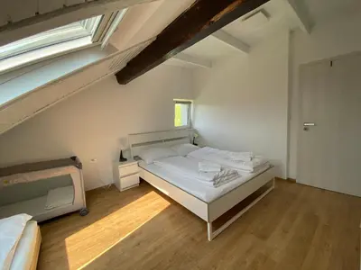 a small bedroom with a bed and a staircase at VILA ADA - 4 Cosy Apartments in Ljubljana