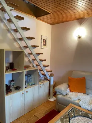 a living room with a staircase and a couch at Vintage Holiday House in Šoštanj